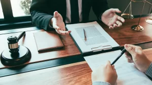 a truck accident lawyer sitting at a table with a pen and paper talking to an attorney