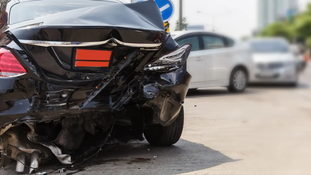 Rear-end damage to a black car after an accident.