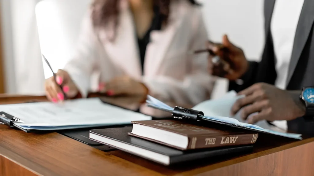 Legal professionals in discussion with law book and documents on desk
