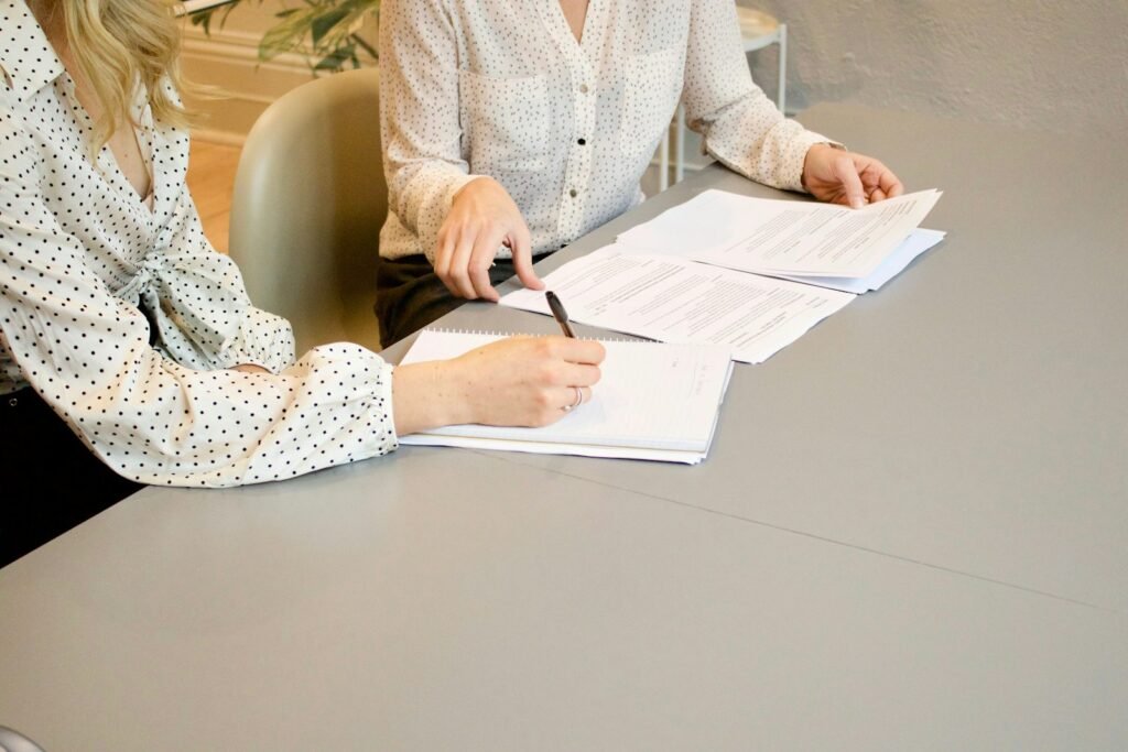 Person signing legal documents at a table