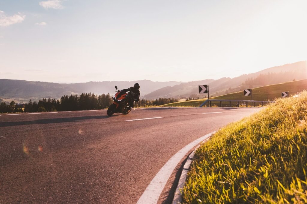 Motorcyclist in a black jacket riding on an open road