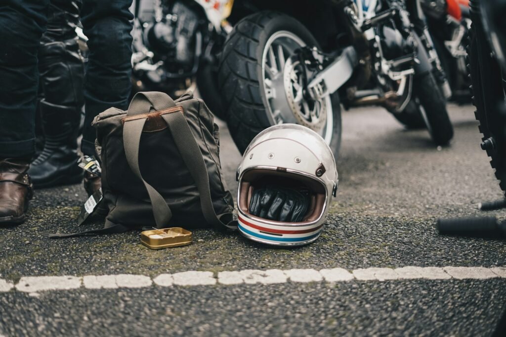 White motorcycle helmet and backpack lying on the road