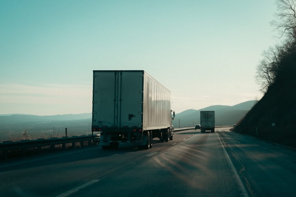 Two semi trucks driving on a highway