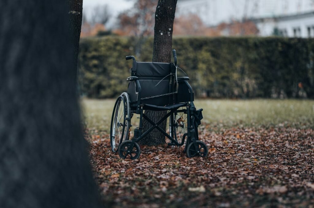 Empty wheelchair sitting under a tree in a park