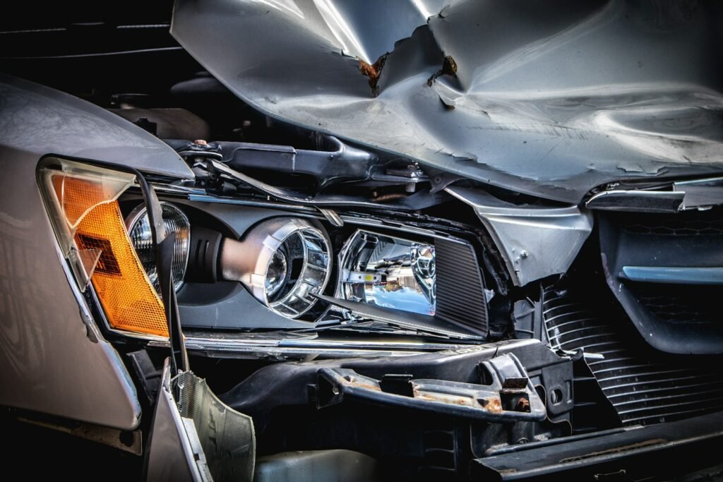 Damaged silver car with a crushed hood after a collision