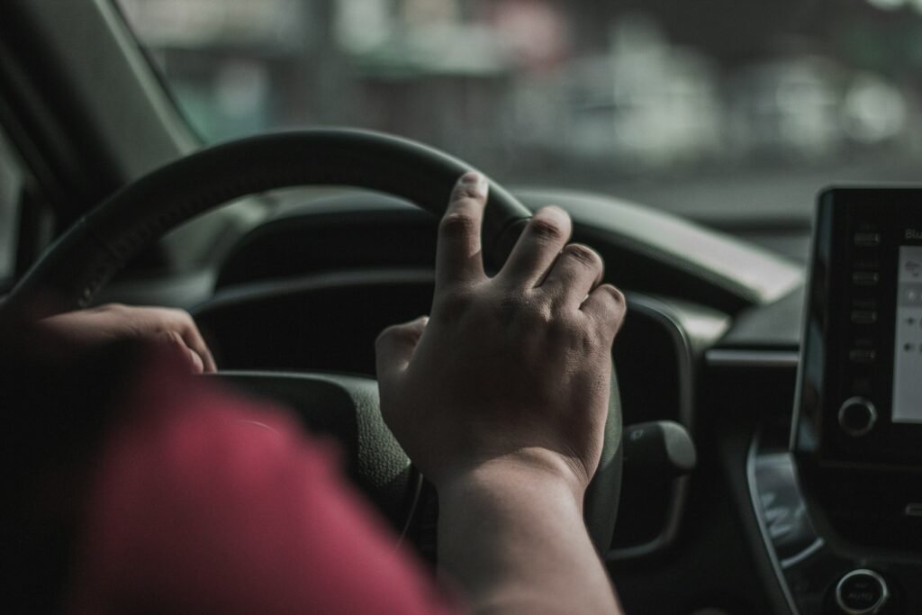 Driver with a hand on the steering wheel