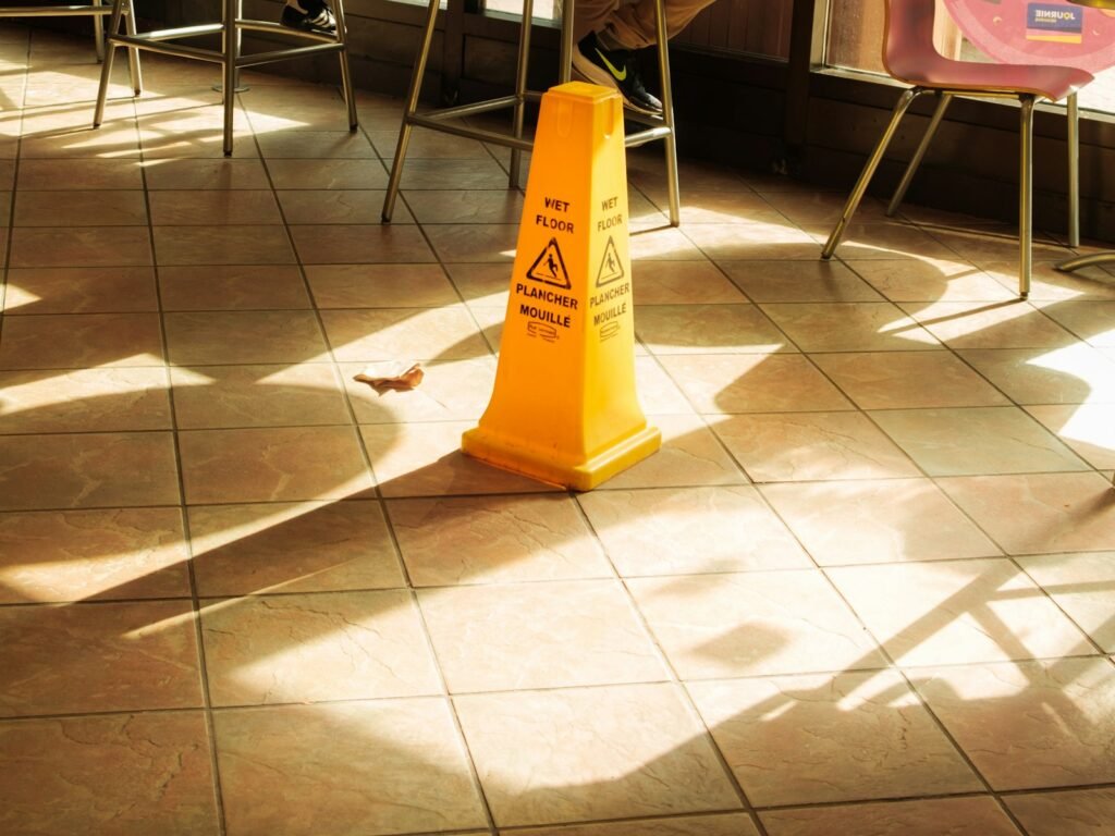 Yellow wet floor caution sign on a tiled floor