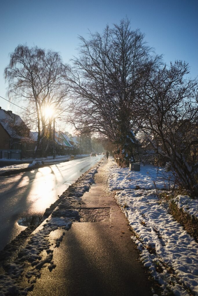Wet street and sidewalk with snow in winter