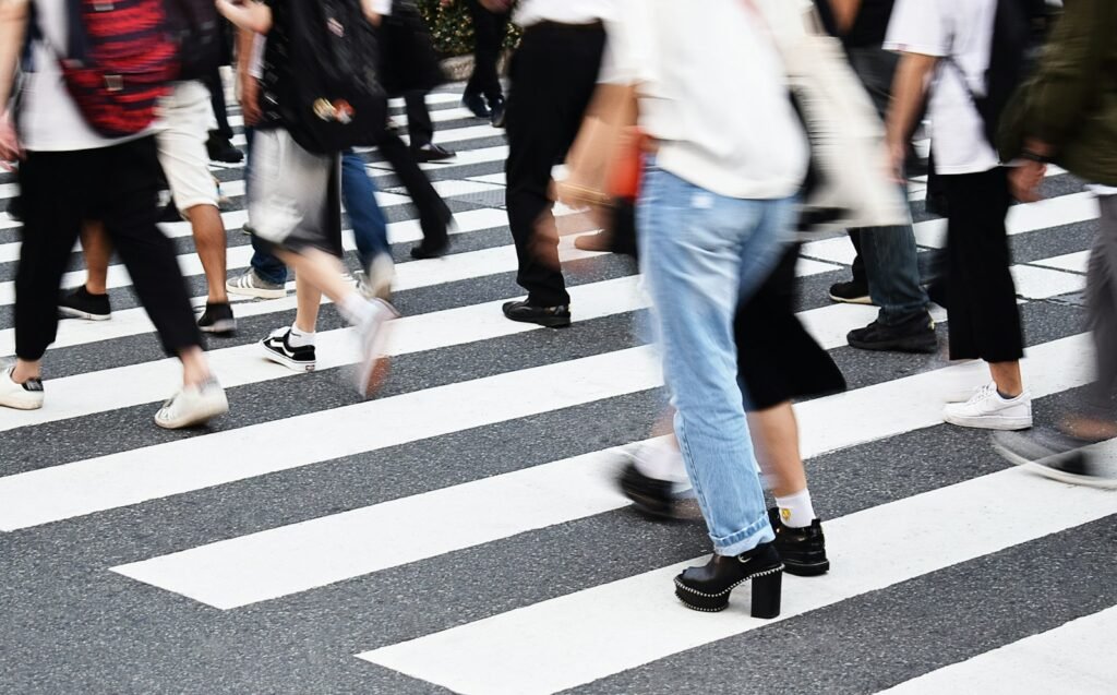 People walking across a striped crosswalk