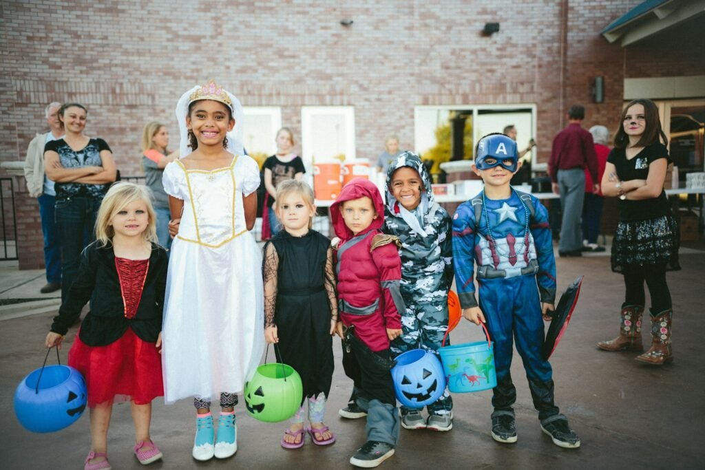 Children in Halloween costumes holding trick-or-treat buckets