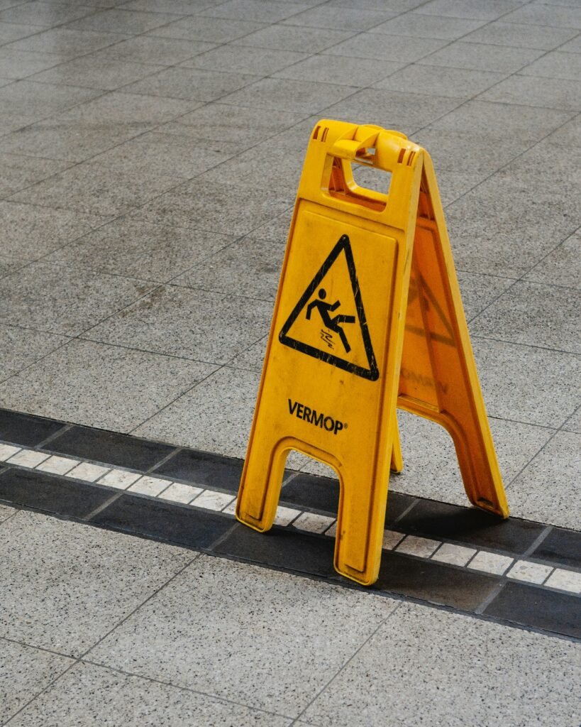 Yellow caution sign on the side of a walkway