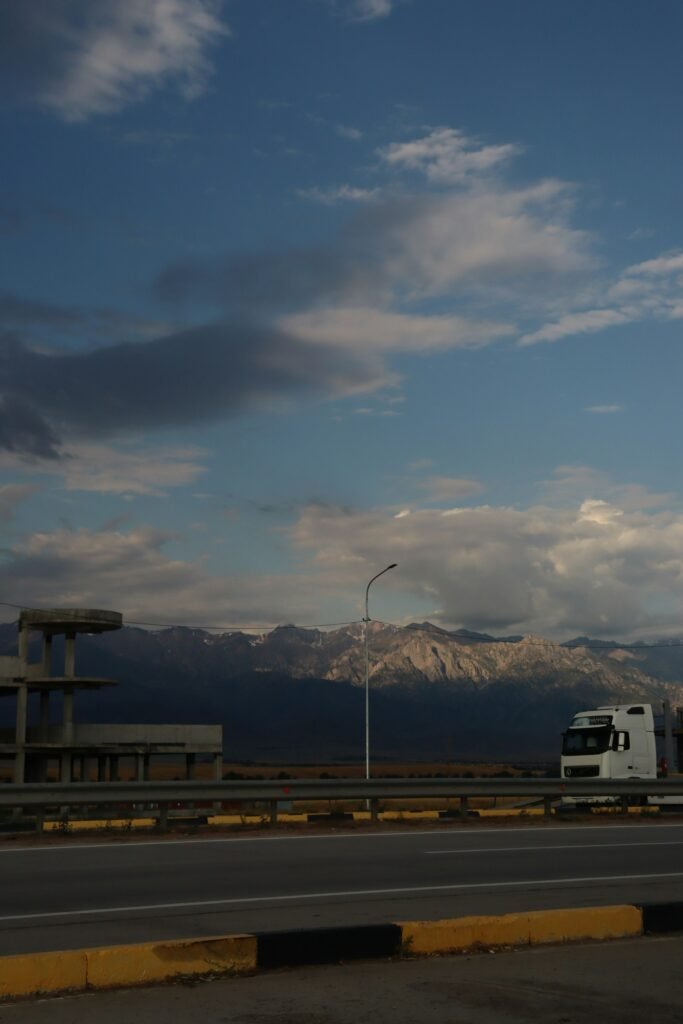 Semi truck on a highway with mountains in the background